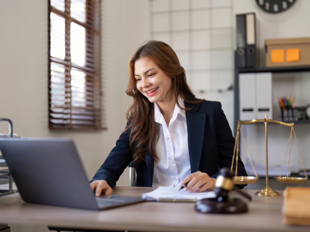 a female attorney with long dark hair in a navy blazer sits in her office reviewing information for her sba 7(a) application to finance her law firm