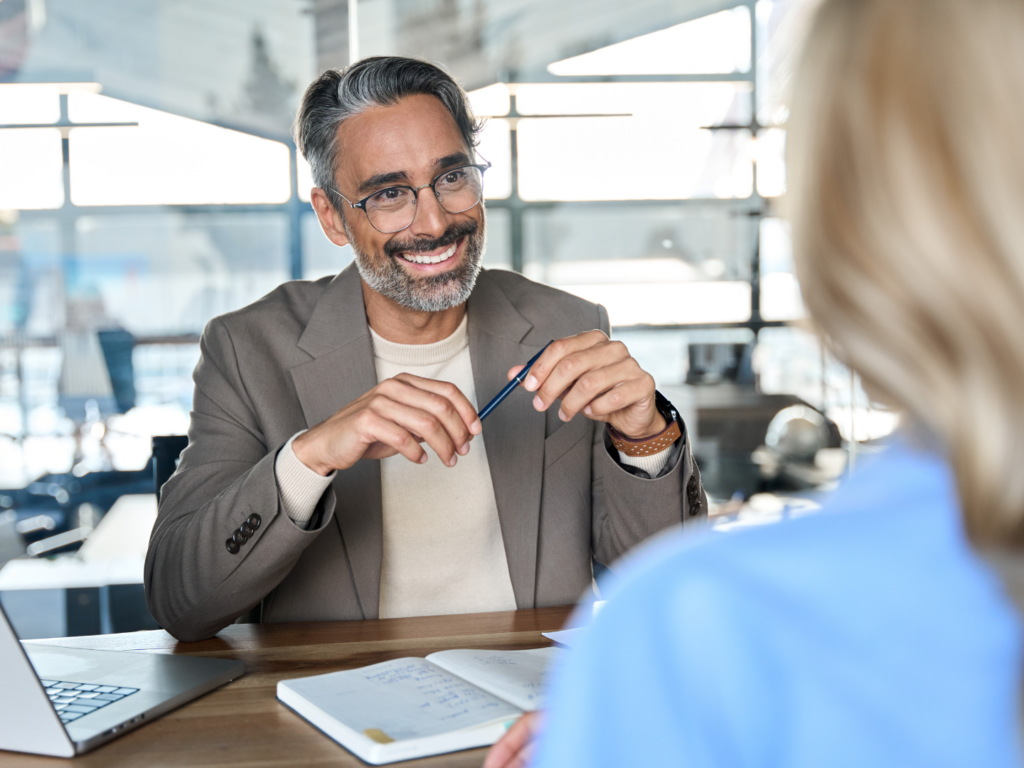 a middle aged estate attorney with medium brown skin and black and gray hair reviews options for account opening for estate management options with a client