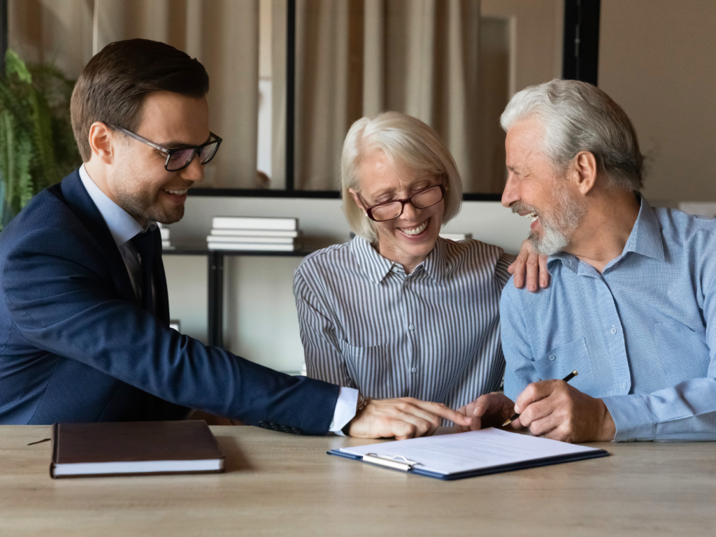 an estate attorney sits with a senior couple reviewing estate management options including estate management banking solutions